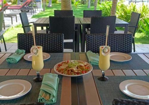 a table with a plate of food and two glasses of juice at SINA SUITES CANCUN - Adults Only in Cancún