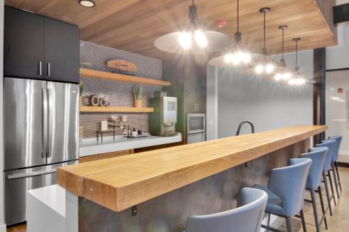a kitchen with a long counter and blue chairs at Rustic Meets Modern 2BR 2BA in Greenville