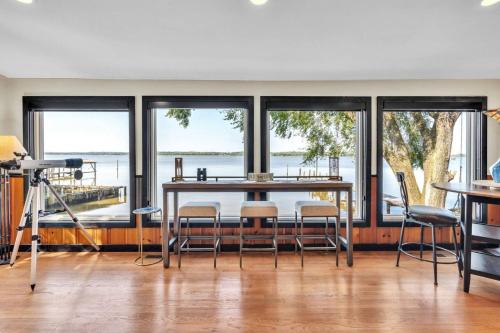 a dining room with a table and chairs and windows at Downs By The River 2 Bedrooms 1 Bathroom in Prince Frederick