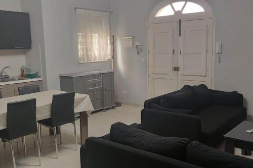 a living room with a couch and a table at Cosy two bedroom maisonette in Xewkija