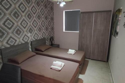 a small bedroom with two beds and a cabinet at Cosy two bedroom maisonette in Xewkija