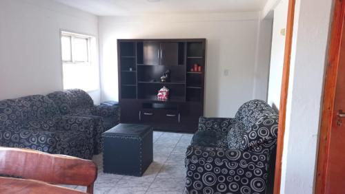 a living room with a couch and a chair at Departamento Amplio Familiar in Ushuaia