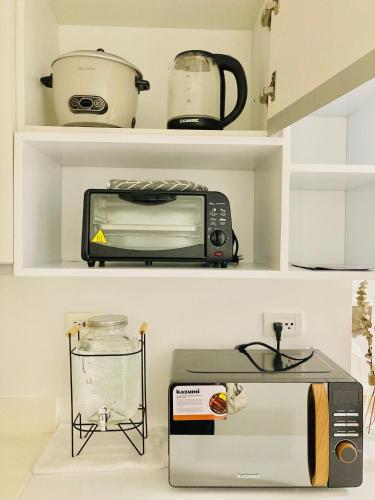 a kitchen shelf with a toaster oven and a microwave at Premium & Spacious Studio with PS4, Karaoke & Netflix in San Fernando