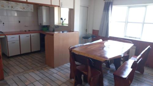 a kitchen with a wooden table and a table and chairs at Departamento Amplio Familiar in Ushuaia