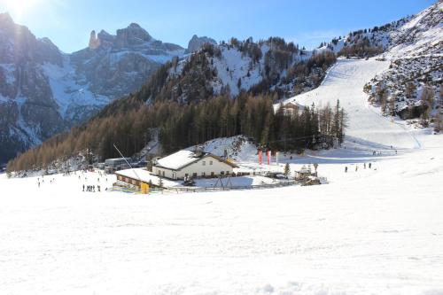 a snow covered mountain with a ski lodge on a ski slope at Garni Diamant in Colfosco