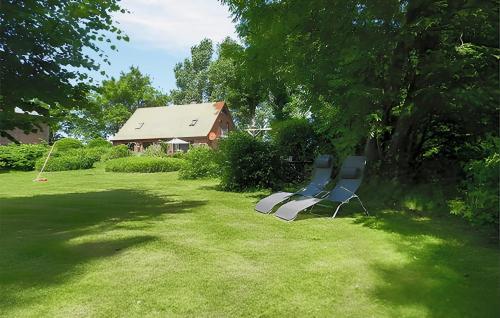 due panche sedute sull'erba di fronte a una casa di Ferienwohnung Altenkirchen a Gudderitz