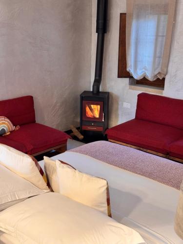 a room with two beds and a wood stove at Blerina's Agritourism Concept in Laknas