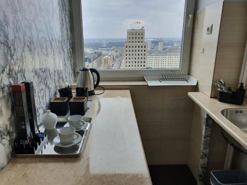 a kitchen with a sink and a window with a view at Amazing View 19 floor! Metro Świętokrzyska in Warsaw