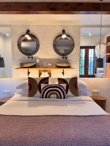 a bedroom with a bed with two mirrors on the wall at Blerina's Agritourism Concept in Laknas