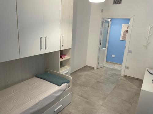 a bedroom with a bed and white cabinets and a hallway at Casa 99 in Amendolara