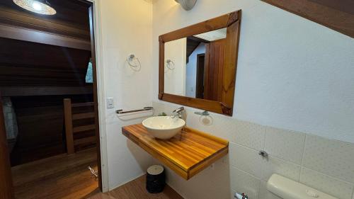 un bagno con lavandino e specchio di Casa Centro MONTE VERDE,MG 12 PESSOAS a Monte Verde
