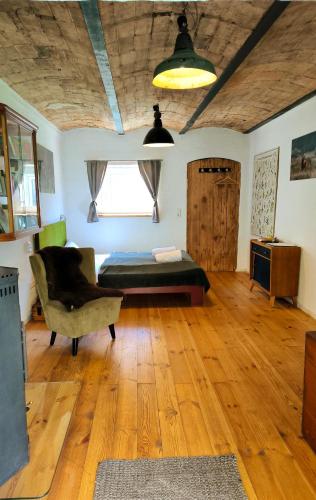 a living room with a bed and a chair at Gästesuite am Waldrand, Ausstieg auf Zeit in Heideblick