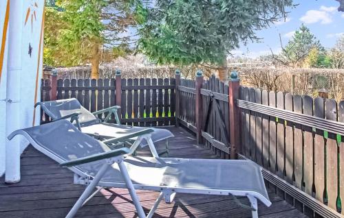 two lawn chairs sitting on a deck next to a fence at Ferienhaus Waren Müritz in Waren