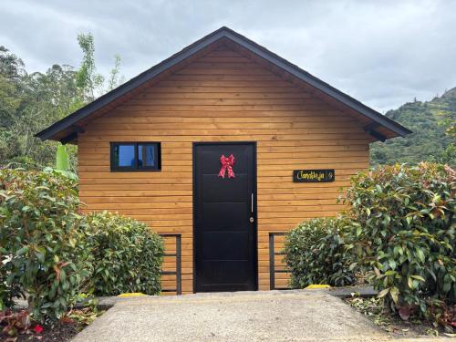 a house with a black door with a red bow on it at ocobos club campestre in Tibirita