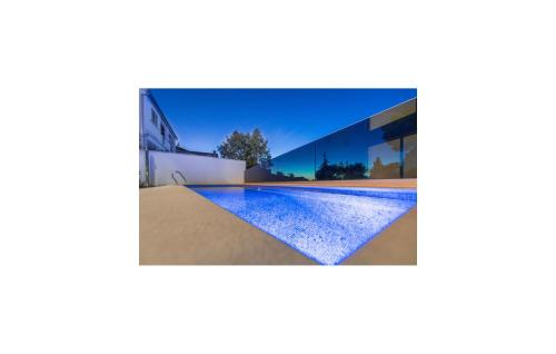 a house with a swimming pool in front of it at Luxurious Apartment In Postira in Postira