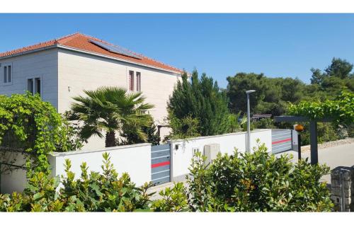 a white house with a fence in front of it at Luxurious Apartment In Postira in Postira