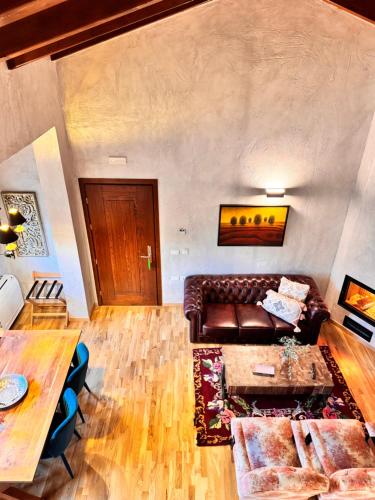 a living room with a leather couch and a table at Blerina's Agritourism Concept in Laknas