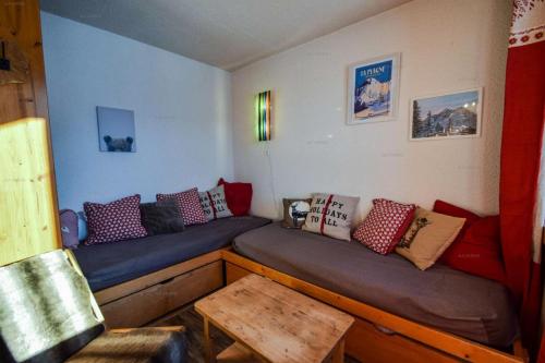 Cette chambre dispose d'un canapé et d'oreillers. dans l'établissement Résidence Les Gentianes - Studio 3/4 pers -LES GENTIANES - PLAGNE VILLAGES MAE-4894, à Aime La Plagne