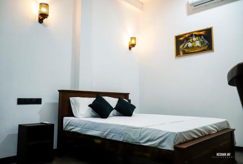 Un dormitorio con una cama con dos almohadas encima. en Belle villa, en Mirissa