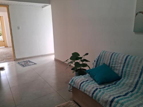 a living room with a couch and a potted plant at Espaço Tranquilo-preço até 4 hóspedes in Pôrto Feliz