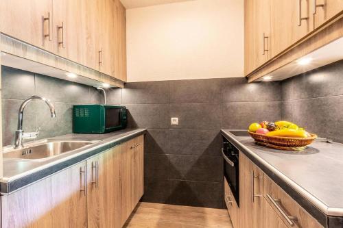 une cuisine avec un bol de fruits sur le comptoir dans l'établissement Résidence Nantchu - NANTCHU 18 MAE-4531, à Les Allues