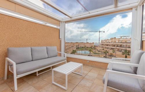 balcón con sofá y vistas a la ciudad en Cozy Home In Torre De La Horadada, en Torre de la Horadada
