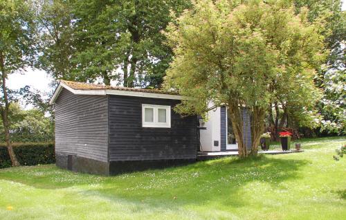 a small house in a yard with a tree at 1 Bedroom Stunning Home In Ejstrupholm in Krejbjerg