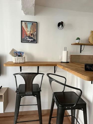 - deux chaises noires assises sous une table et un bureau dans l'établissement Le Petit Urbain, à Troyes