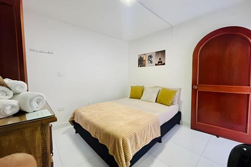 een kleine slaapkamer met een bed en een kast bij ApartaEstudio con balcón e iluminado Cerca de todo in Envigado