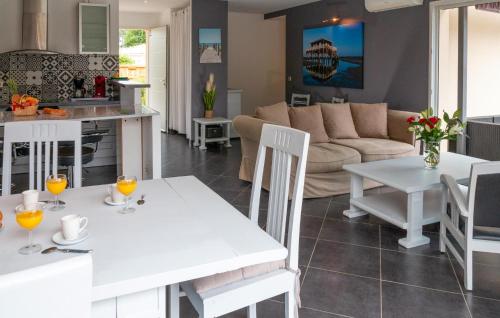 une cuisine et un salon avec une table et des chaises blanches dans l'établissement Beautiful Home In Ares, à Arès