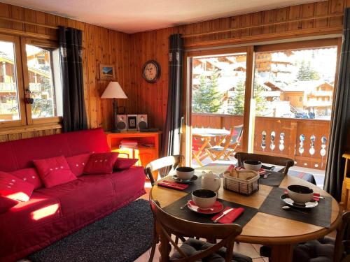 un salon avec un canapé rouge et une table dans l'établissement Résidence Alpages D - ALPAGES D5 MAE-1141, à Les Allues