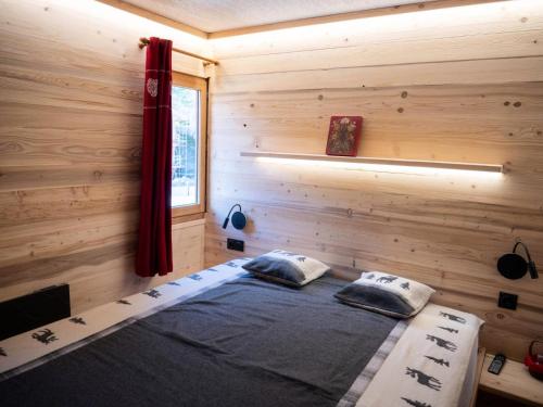 une chambre avec un lit dans une cabane en bois dans l'établissement Résidence Alpages D - ALPAGES D5 MAE-1141, à Les Allues