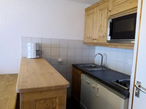 une petite cuisine avec un évier et un micro-ondes dans l'établissement Résidence Arpasson - ARPASSON 73 MAE-1151, à Les Allues