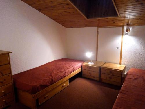 une petite chambre avec un lit et deux tables de nuit dans l'établissement Résidence Arpasson - ARPASSON 73 MAE-1151, à Les Allues