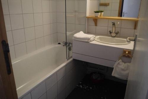 une salle de bain avec une baignoire blanche et un lavabo dans l'établissement Résidence Arpasson - ARPASSON 73 MAE-1151, à Les Allues