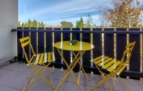 d'une table jaune et de deux chaises sur un balcon. dans l'établissement Gorgeous Apartment In Saint-Georges-De-Didon, à Saint-Georges-de-Didonne