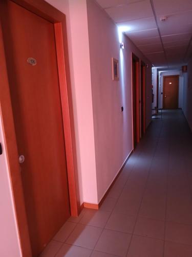 an empty hallway with orange walls and a corridorngthngthngthngthngthngthngth at Hotel Ponsacco HP in Ponsacco