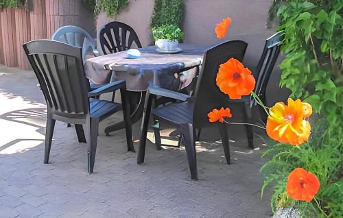 a table and chairs with orange flowers on a patio at Ferienwohnung Kloster in Kloster