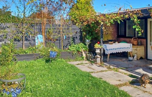 a backyard with a table in the grass at Nice Home In Warmenhuizen With Wifi in Warmenhuizen