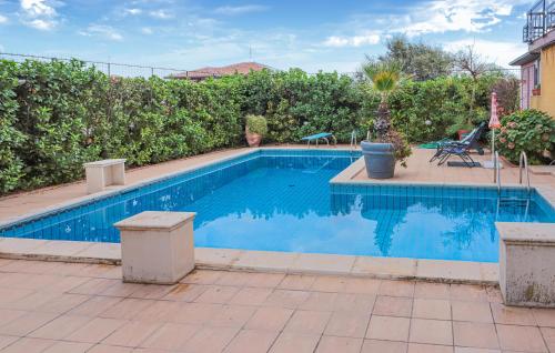 a swimming pool with blue water in a yard at Amazing Home In Trecastagni With Sauna in Trecastagni