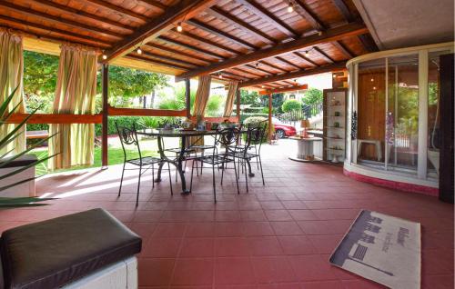 an outdoor patio with chairs and tables and windows at Amazing Home In Trecastagni With Sauna in Trecastagni