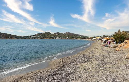 a group of people sitting on a beach near the water at Nice Apartment In Anavissos With Wifi in Anavissos