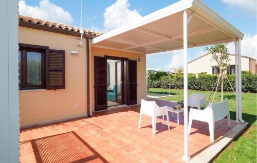 eine Terrasse mit zwei weißen Stühlen und einem Tisch in der Unterkunft 1 Bedroom Gorgeous Home In Marina Di Modica in Marina di Modica