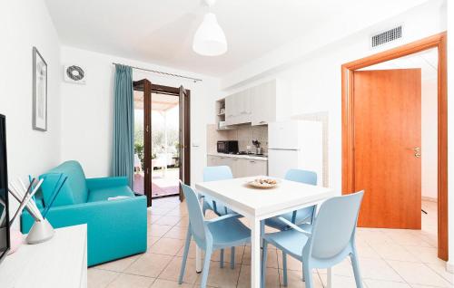 ein Wohnzimmer mit einem weißen Tisch und blauen Stühlen in der Unterkunft 1 Bedroom Gorgeous Home In Marina Di Modica in Marina di Modica