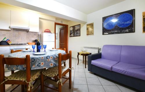 a living room with a table and a purple couch at 2 Bedroom Nice Apartment In Trecastagni in Trecastagni