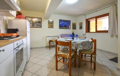 a kitchen with a table with chairs and a refrigerator at 2 Bedroom Nice Apartment In Trecastagni in Trecastagni
