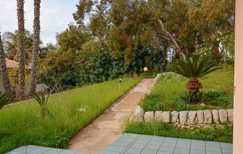 a garden with a stone path and a palm tree at Nice Home In Ragusa With Wifi in Ragusa
