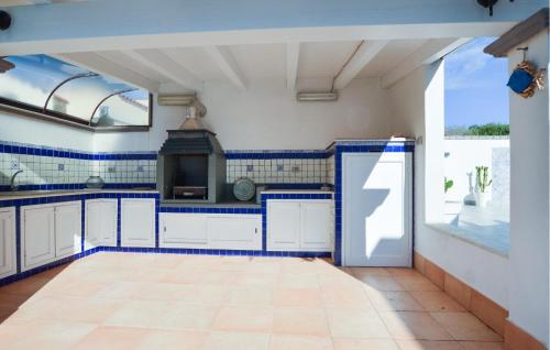 a kitchen with blue and white tiles on the walls at 2 Bedroom Amazing Home In Triscina in Triscina