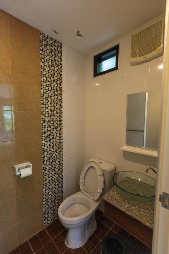 a bathroom with a toilet and a sink and a tub at Jaris Cottage in Nong Nam Daeng