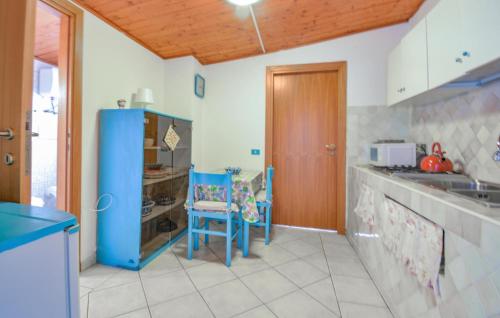 a kitchen with a blue refrigerator and some chairs at Pet Friendly Apartment In Solanas in Solanas